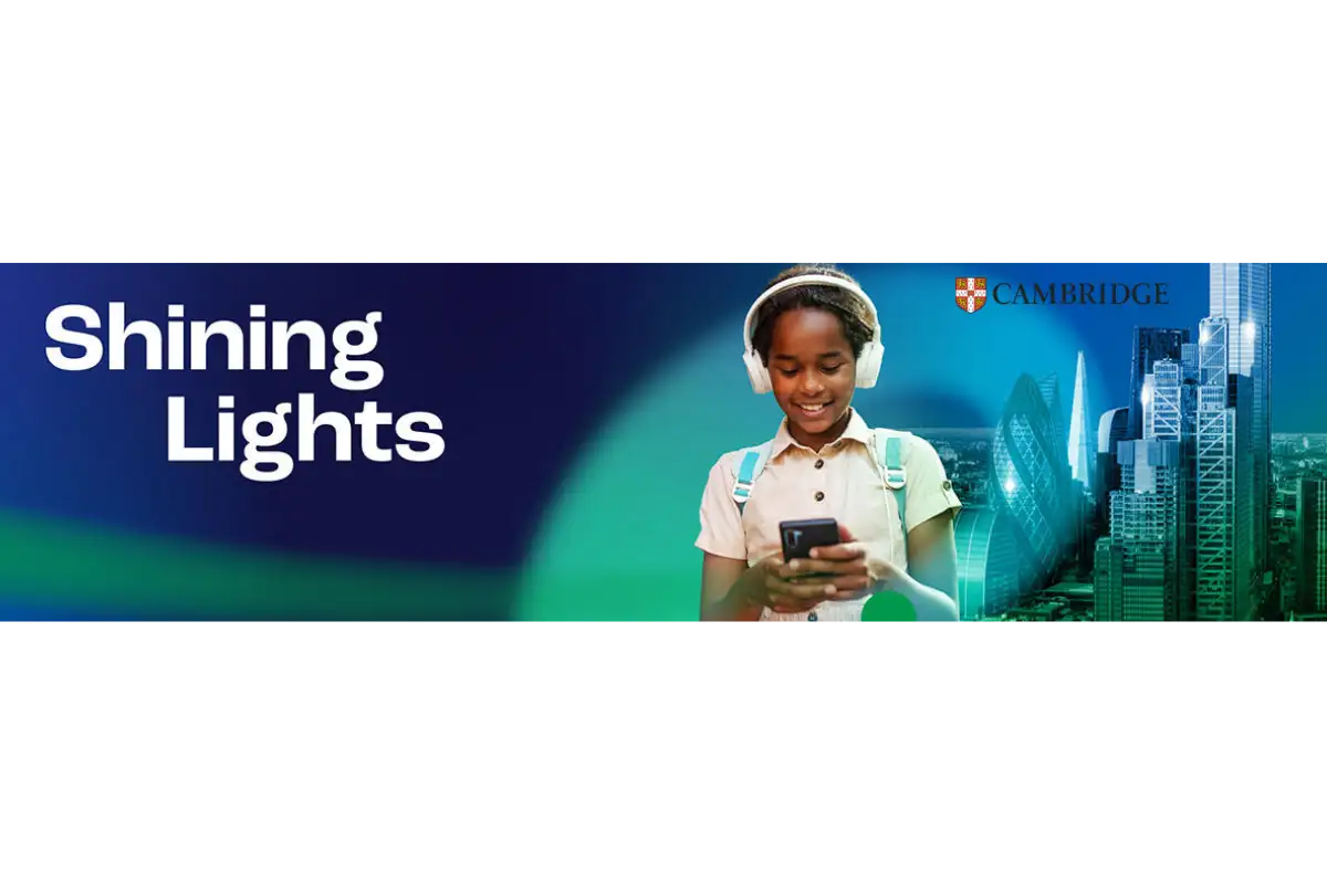 Een jong meisje met witte over-ear hoofdtelefoons en een lichtgekleurde shirt, die een zwarte smartphone vasthoudt.